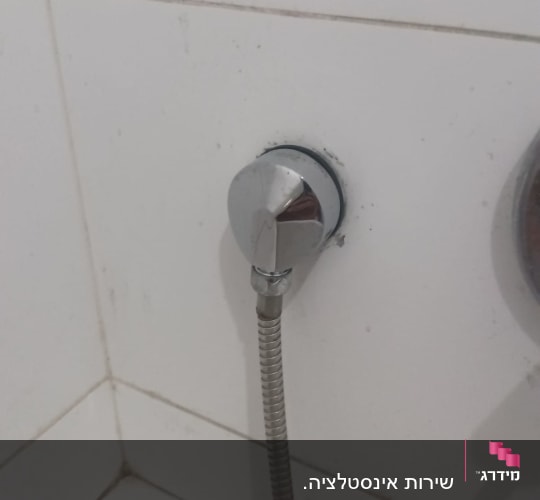 חיבור צינור מתכת לקיר בחדר אמבטיה